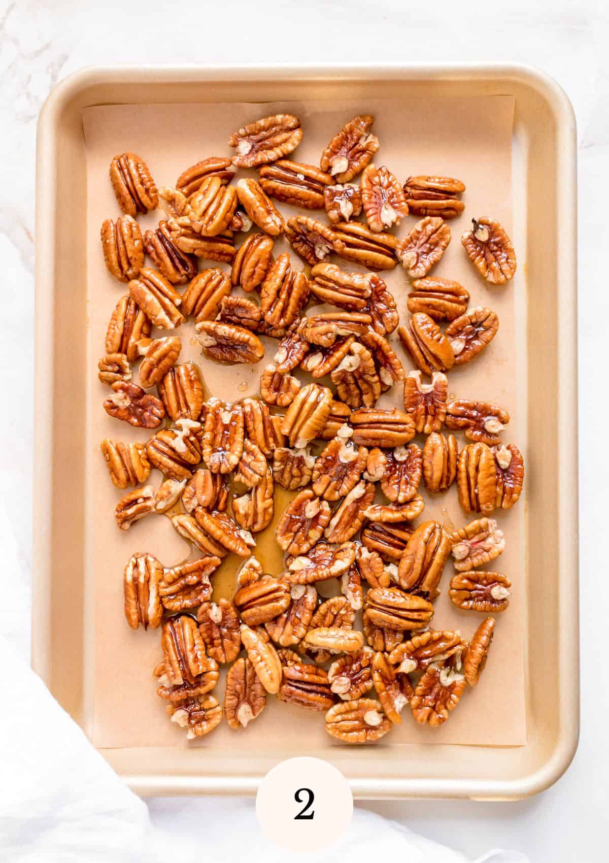 maple roasted pecans on small gold baking sheet.