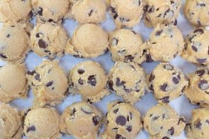 one bowl chocolate chip cookie dough scooped on a sheet pan