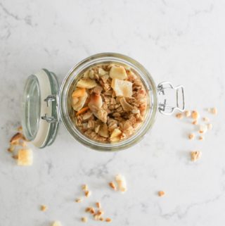 pineapple macadamia nut granola in a jar on marble countertop