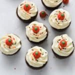 chocolate cupcakes with vanilla buttercream on white concrete