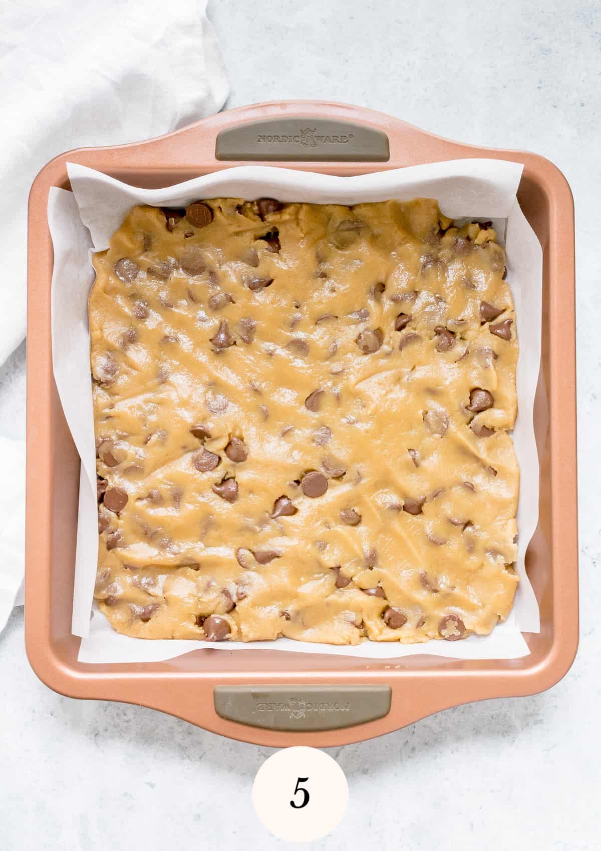 blondie batter in parchment lined baking pan.