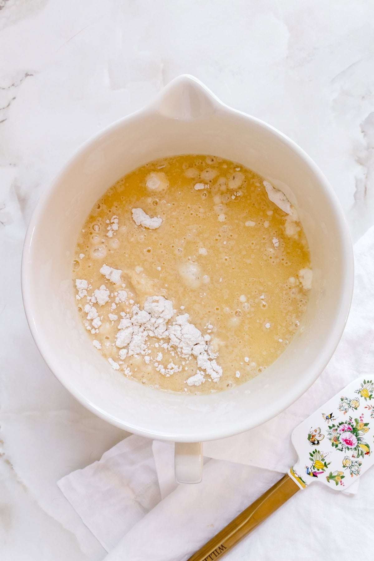 liquid ingredients for gluten free pancakes in a glass mixing bowl.