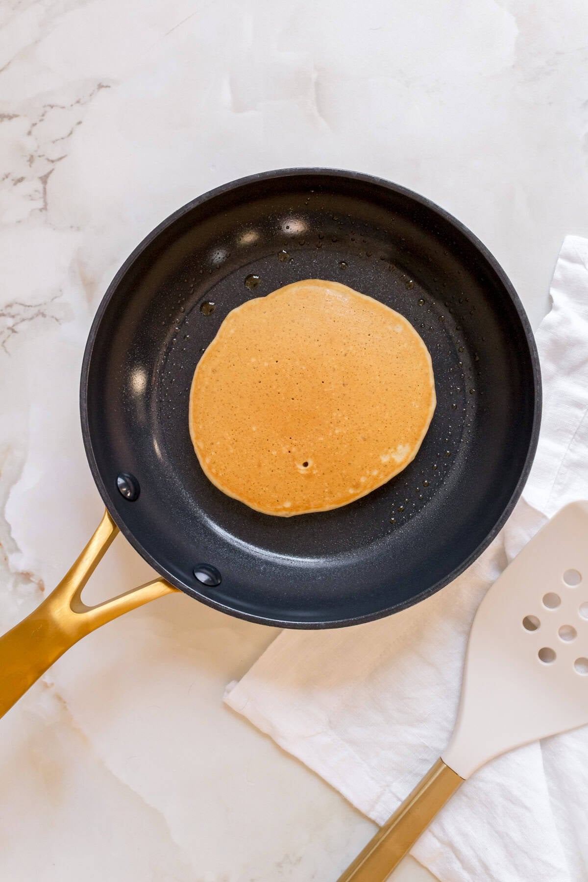 gluten free pancake in a small frying pan.