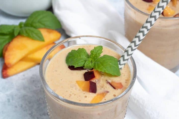almond peach smoothie with mint and a straw