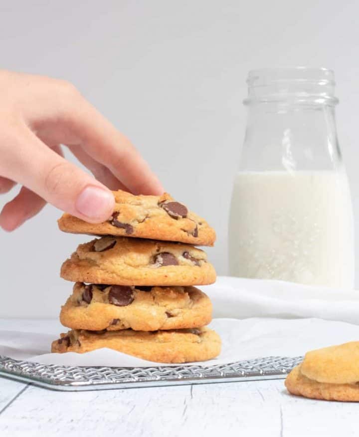 one bowl chocolate chip cookies with hand taking one
