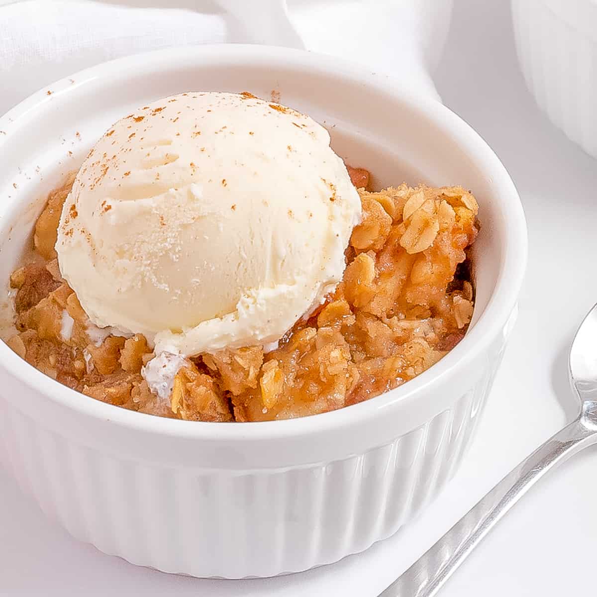 bowl of apple crisp with vanilla ice cream.