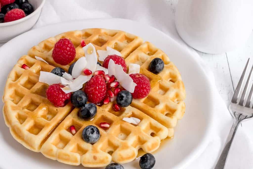 gluten free waffles on white plate with fork