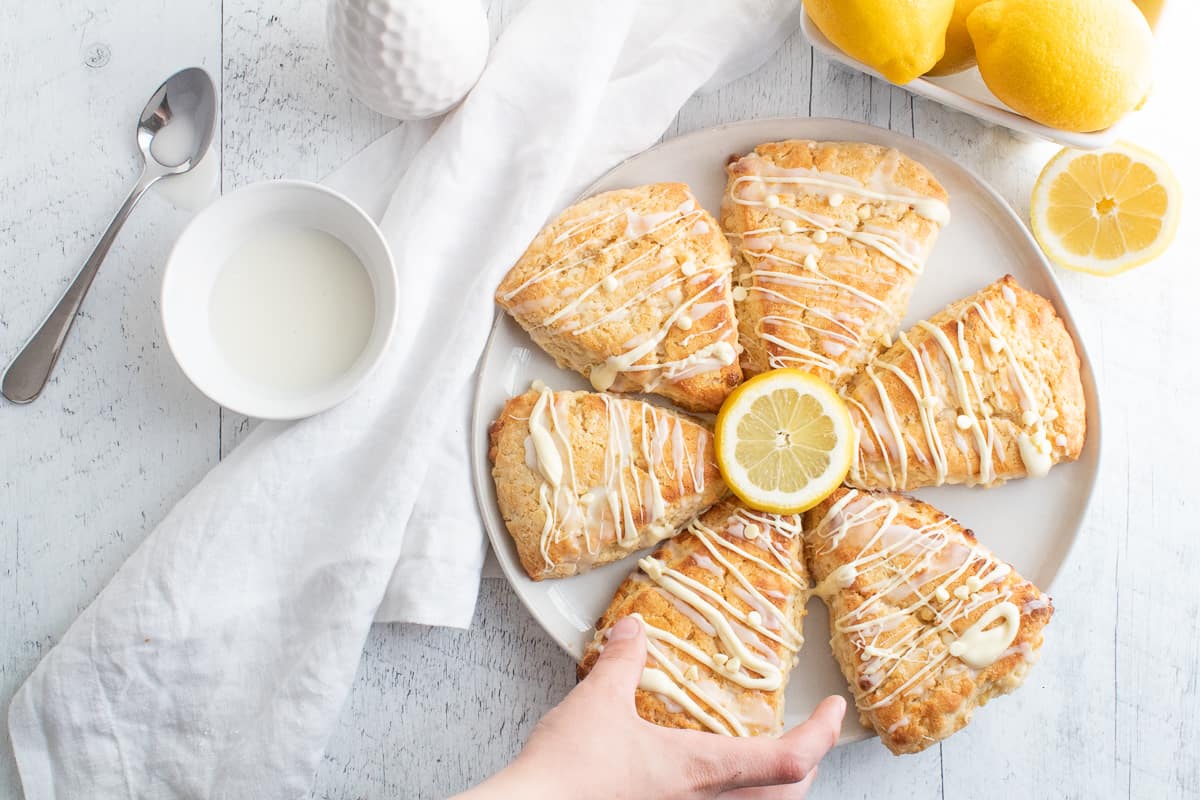 hand reaching for a lemon white chocolate chip scone