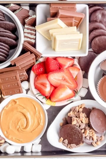ingredients for s'mores dessert board on black tray.