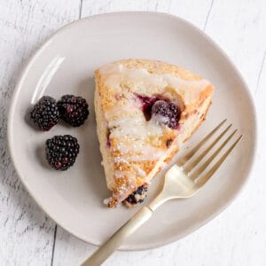 gluten free blackberry scone on plate with berries and fork