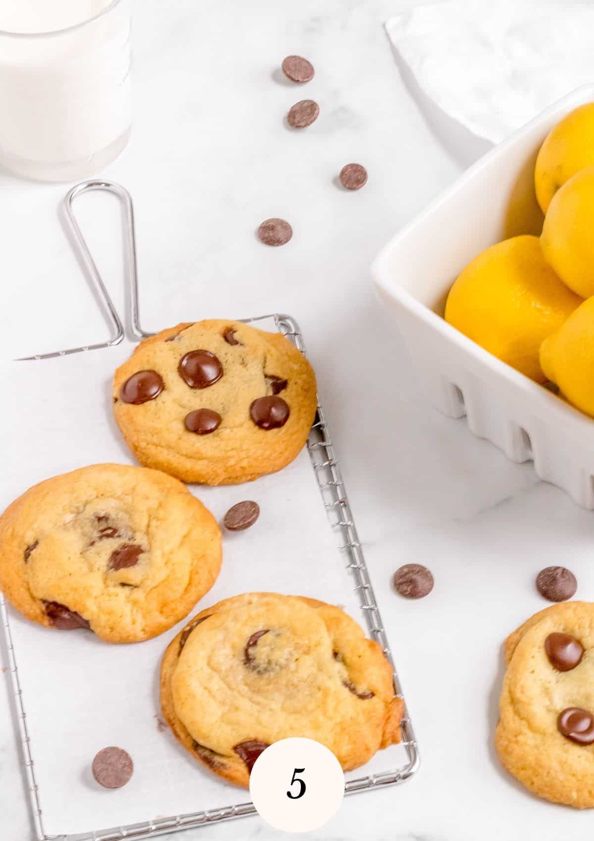 lemon chocolate chip cookies on cooling rack with lemons and milk