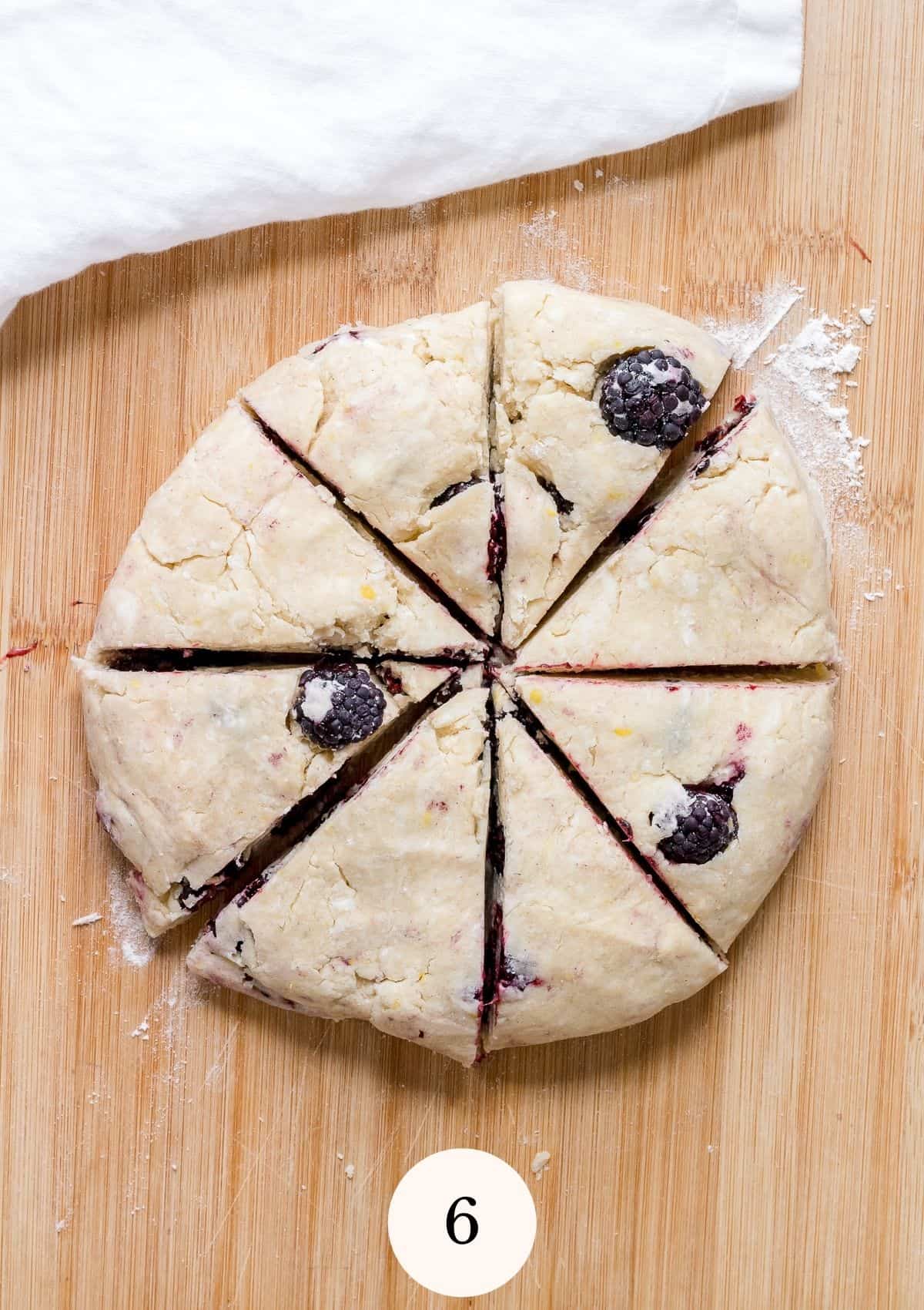 gluten free scone dough cut into wedges on cutting board