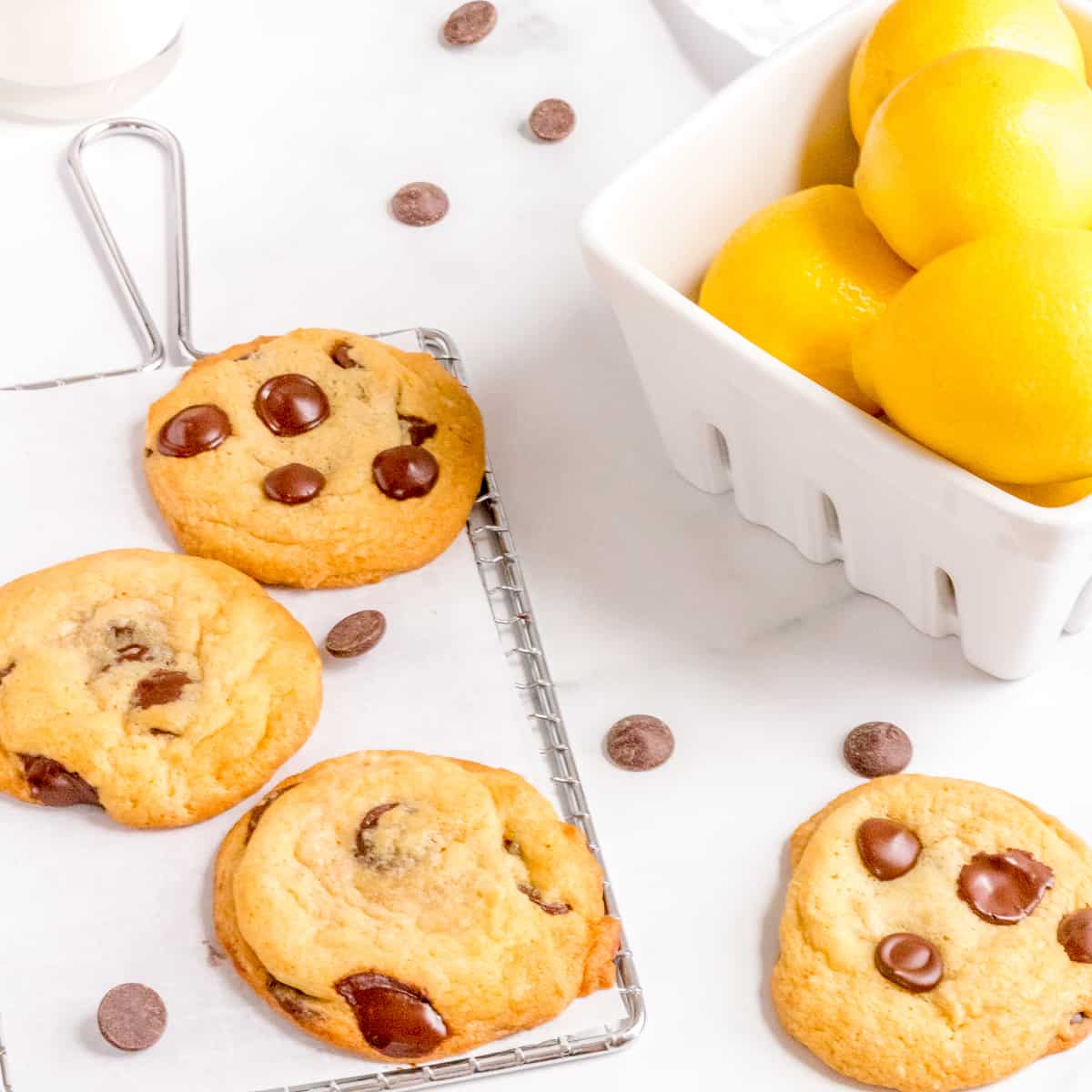 lemon chocolate chip cookies on cooling rack with basket of lemons