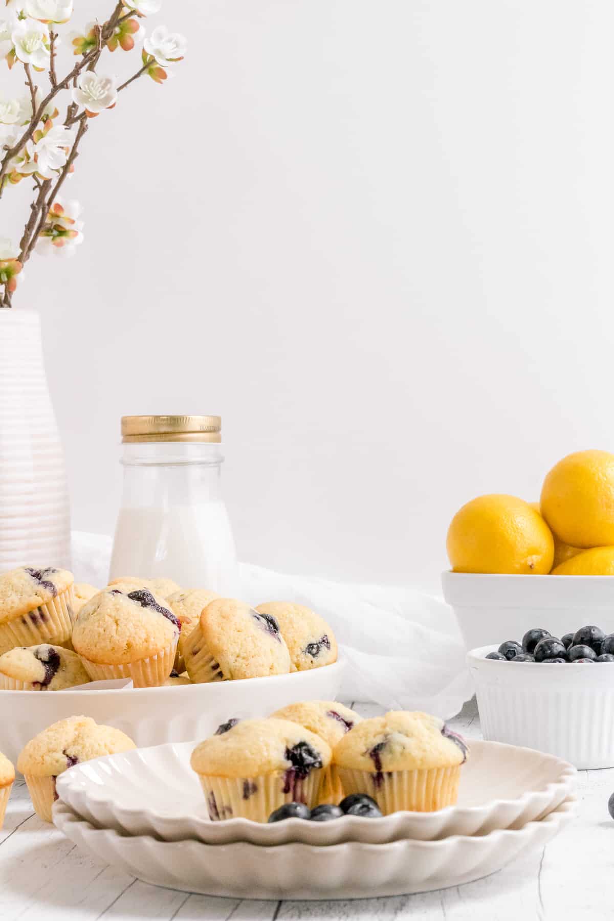 mini blueberry muffins on plate with milk and bowl of lemons