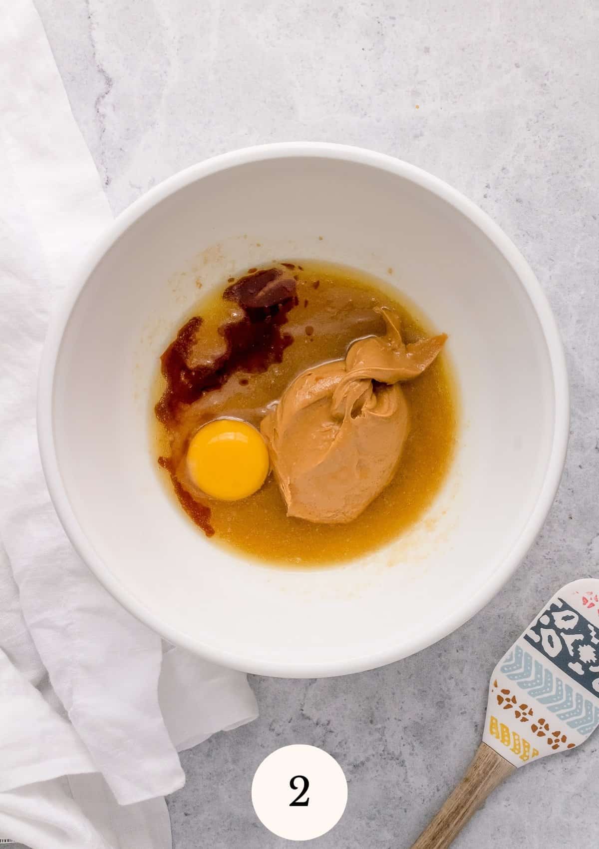 adding egg and peanut butter to mixing bowl