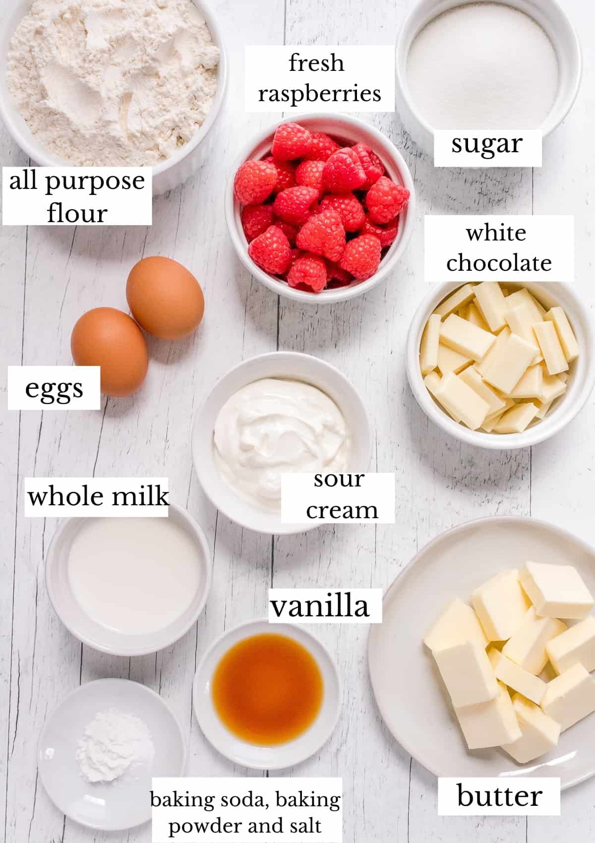 ingredients for white chocolate and raspberry muffins on white board