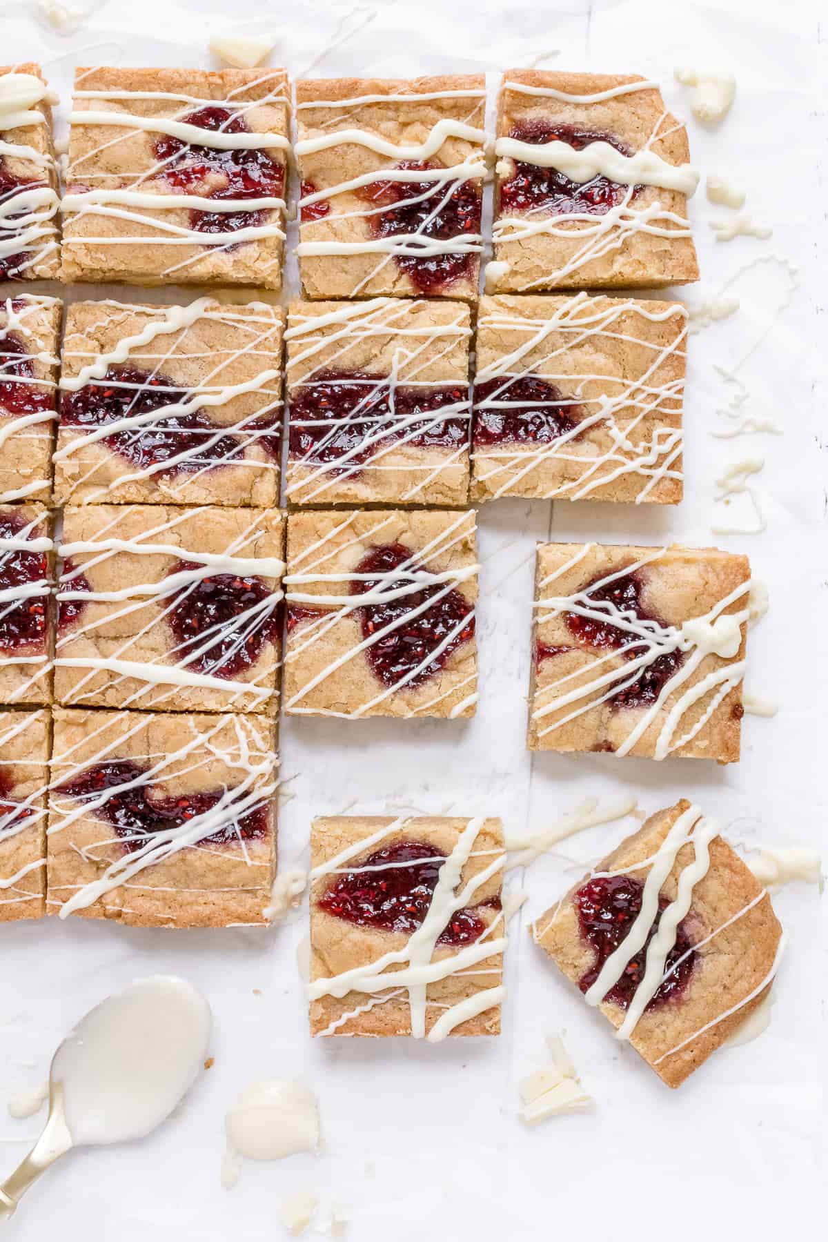 blondies with white chocolate drizzle on parchment