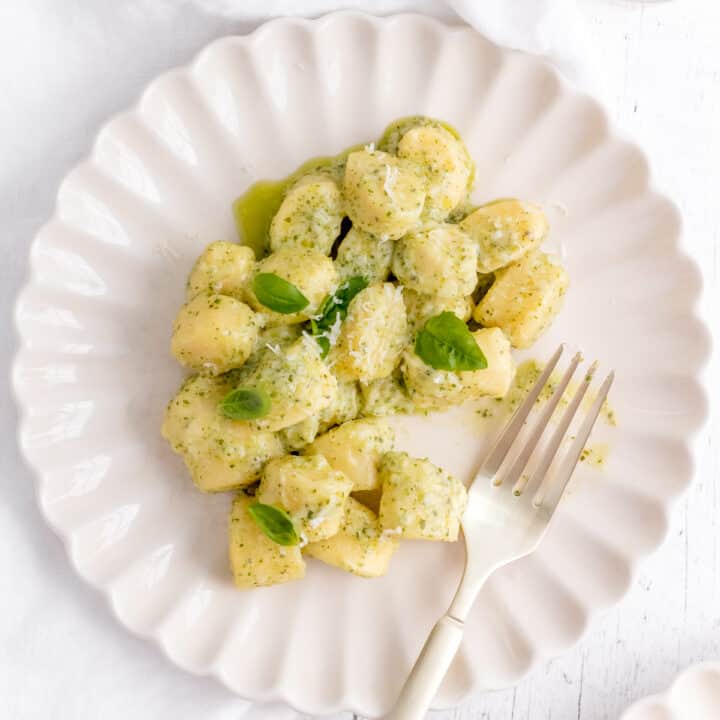 gnocchi pesto with parmesan and basil on white plate