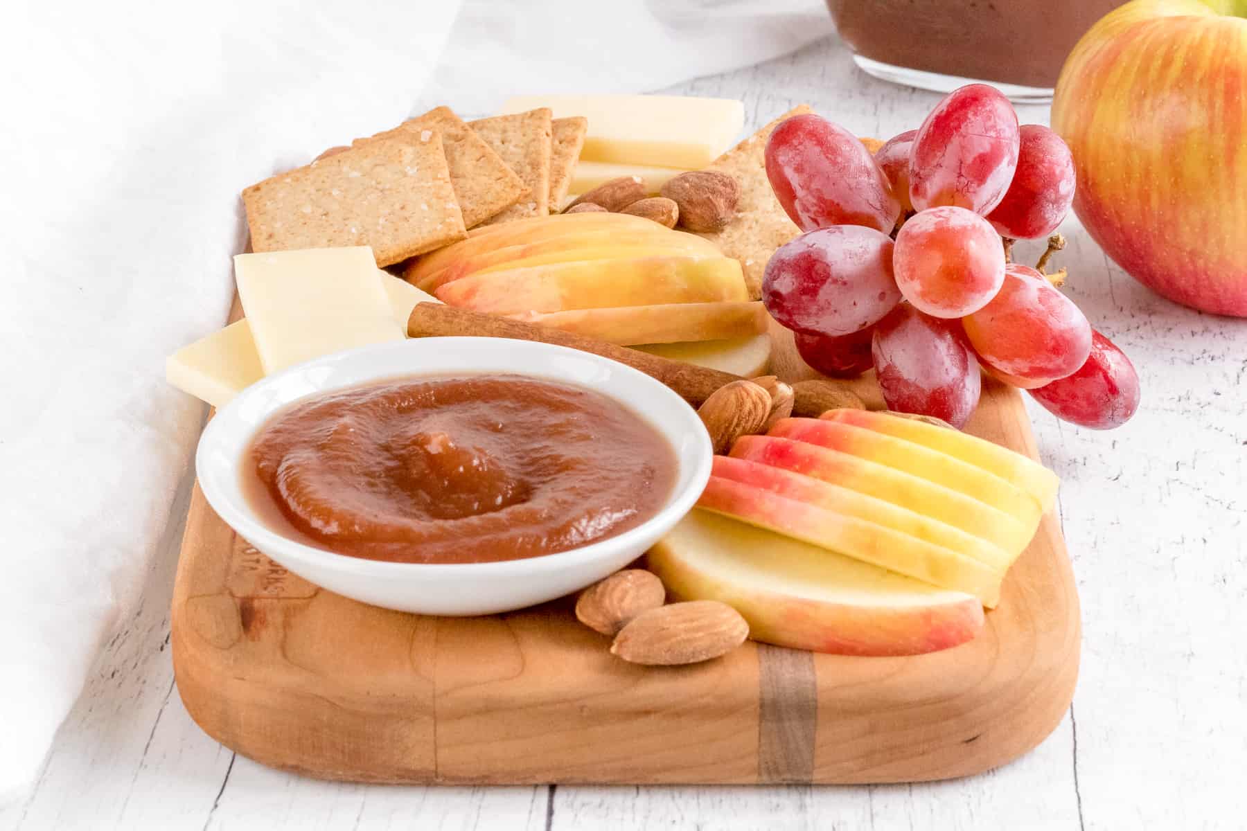 charcuterie board with cheese, apples, grapes and apple butter.