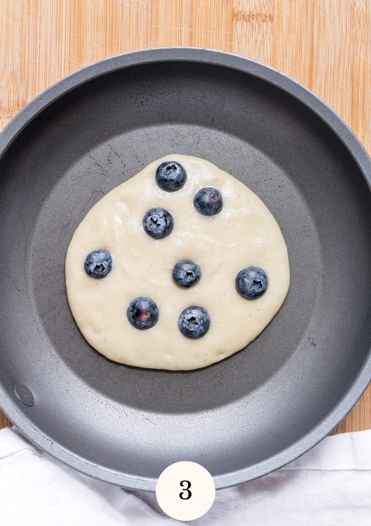 adding blueberries to gluten free pancakes.