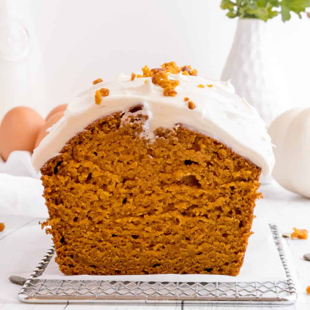 sliced loaf of pumpkin bread with cream cheese icing.