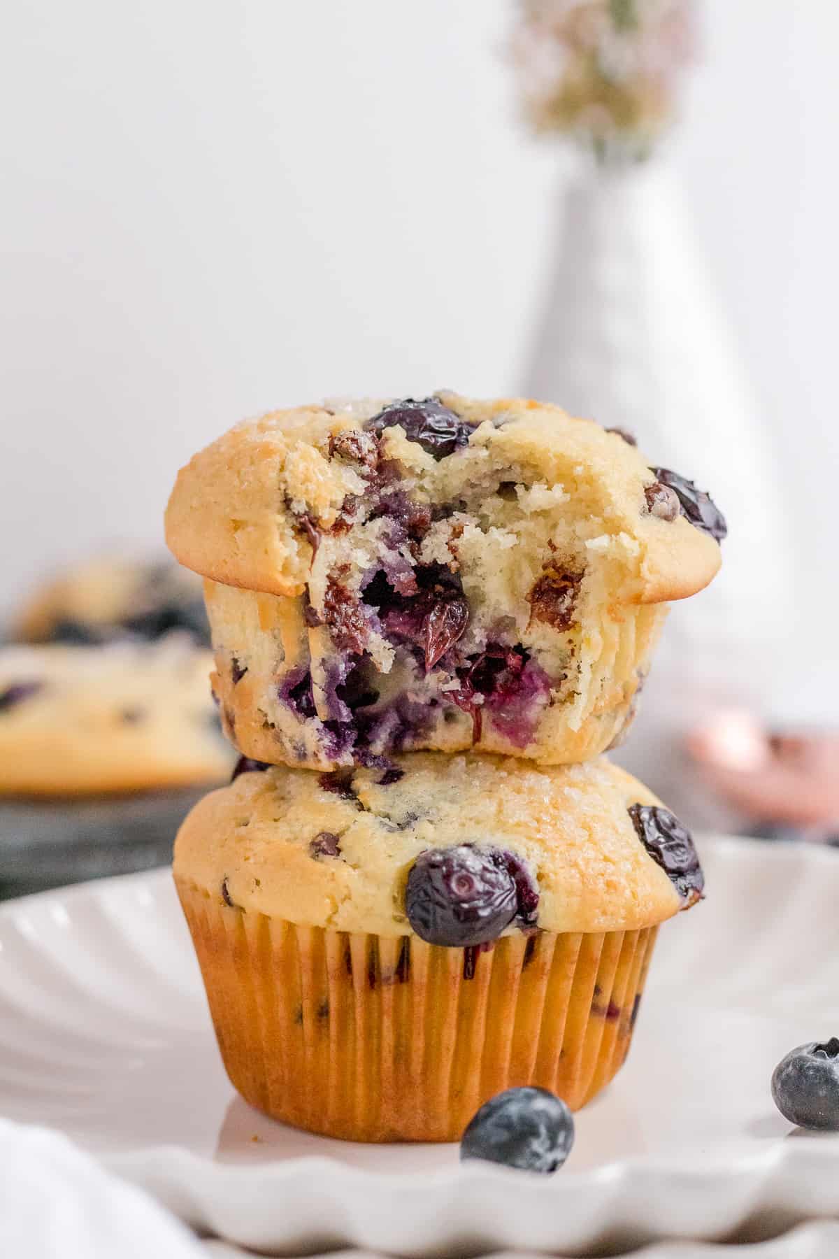 stack of blueberry chocolate chip muffins on scalloped plate.