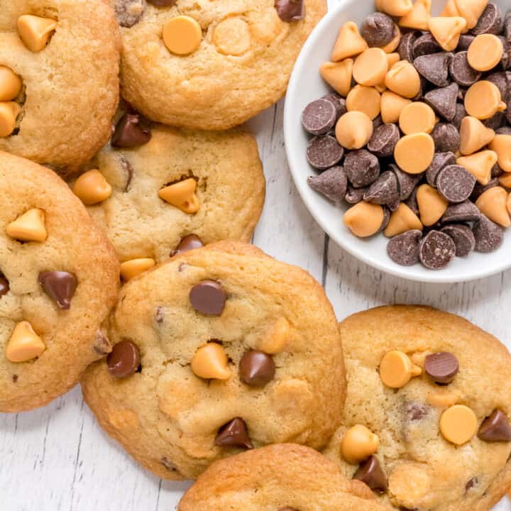 pile of butterscotch chocolate chip cookies with bowl of chocolate and butterscotch chips.