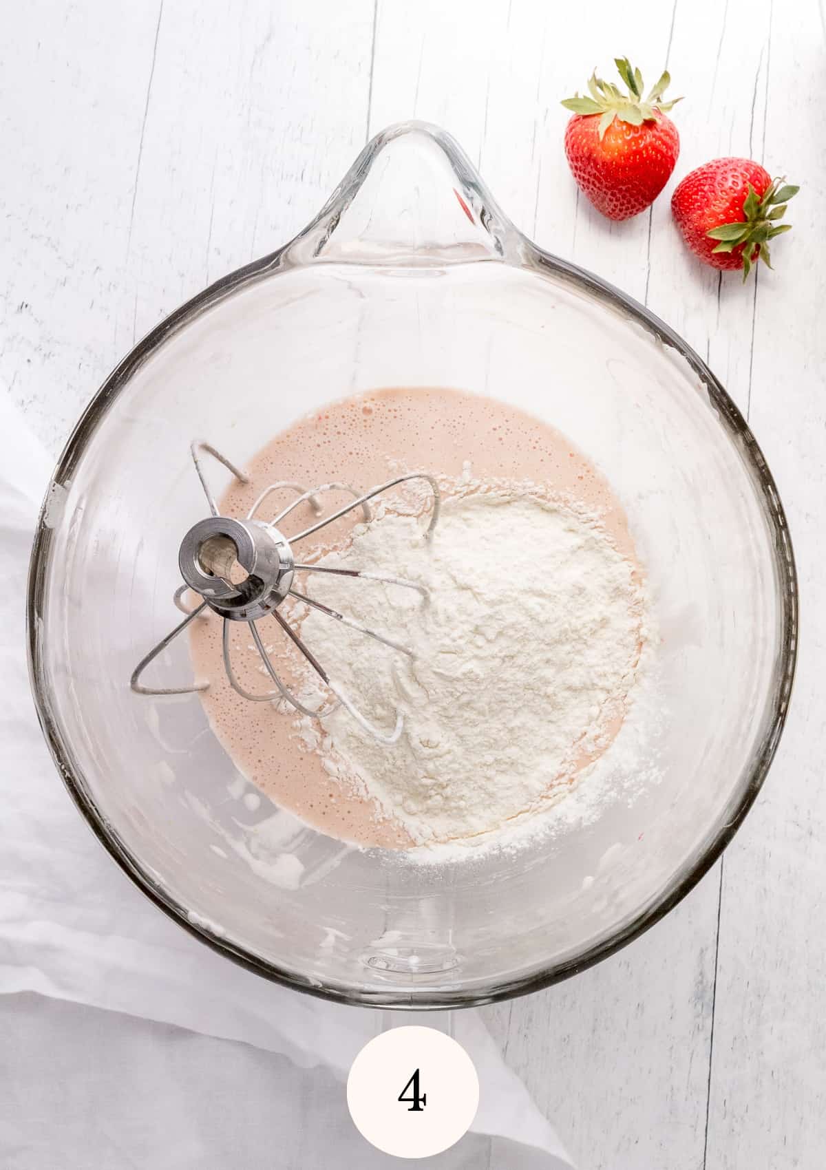 adding dry ingredients to strawberry Madeleine batter.