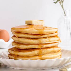 stack of ultimate pancakes with butter and maple syrup.