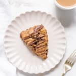 coffee chocolate chip scone on white plate.