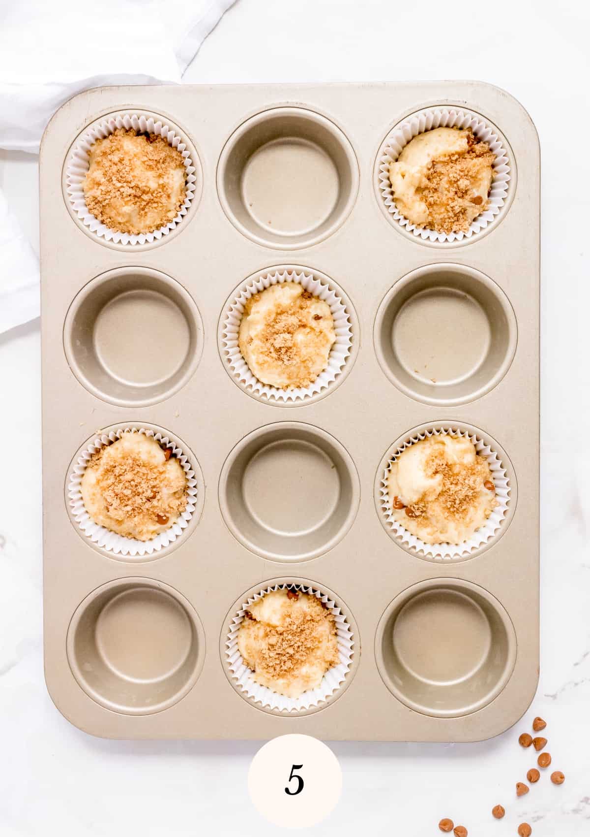 muffin tin filled with batter and streusel.