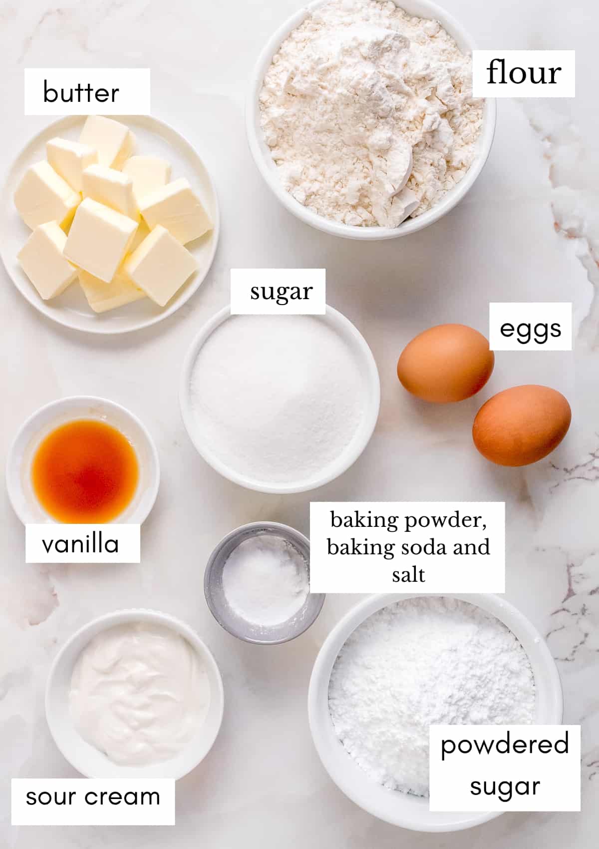 ingredients for almond sugar cookies on marble background.