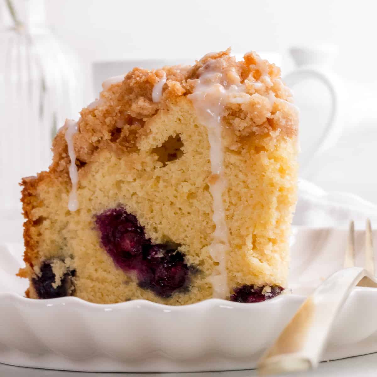 slice of buttermilk blueberry coffee cake with lemon glaze.