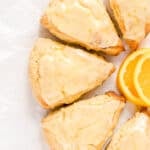 orange scones with orange glaze and slices of fresh orange.