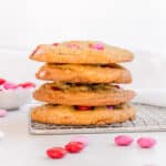 stack of m&m chocolate chip cookies on cooling rack.