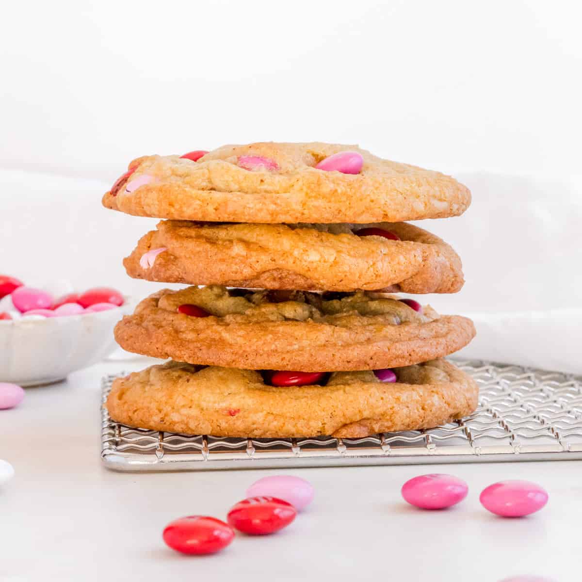 stack of m&m chocolate chip cookies on cooling rack.