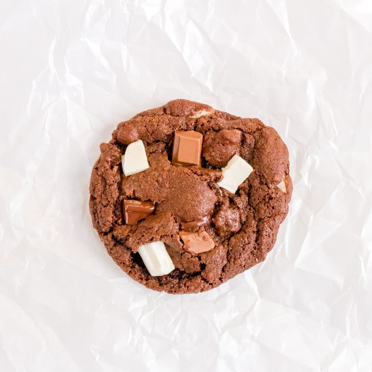 triple chocolate chunk cookie on white parchment paper.