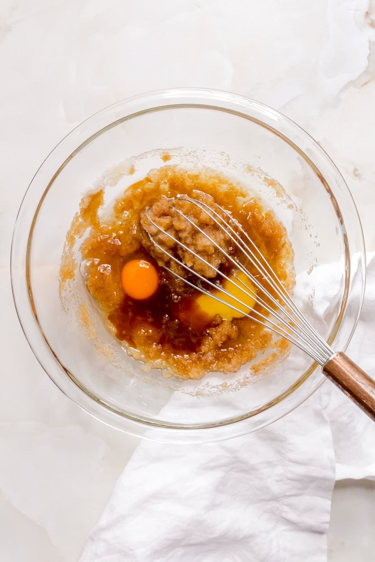Butter, sugar and eggs in a glass mixing bowl.