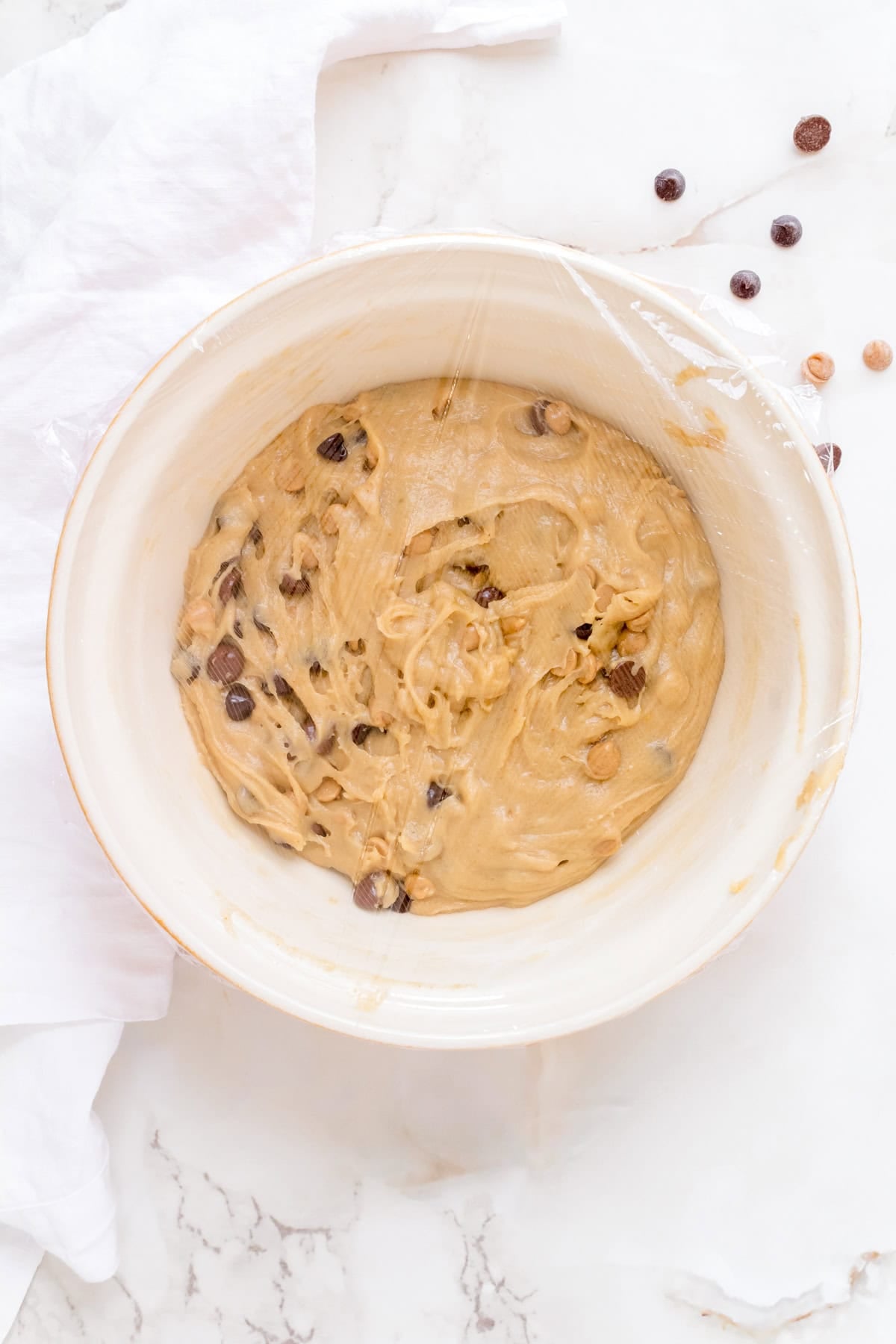 cookie dough in bowl covered with plastic wrap.