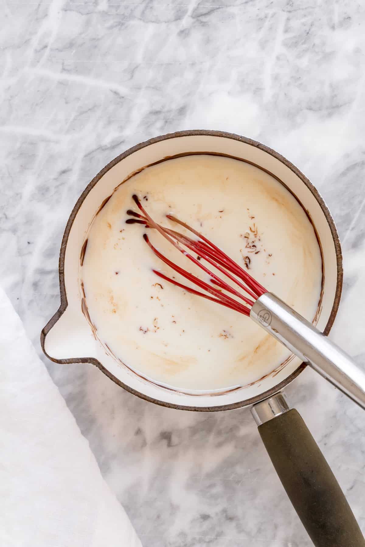 warm milk and chocolate melted in white saucepan.