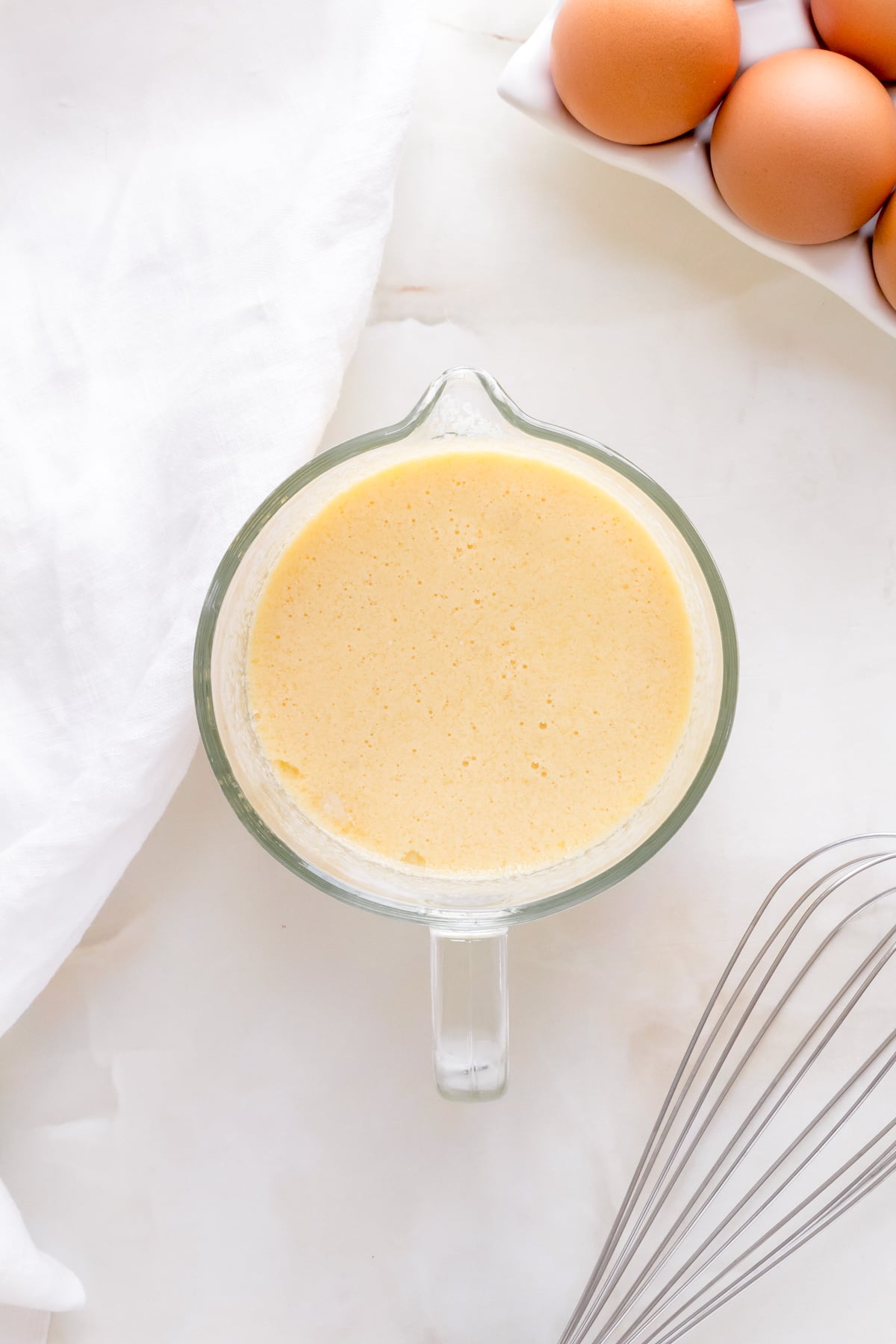 Eggs, buttermilk, canola oil and vanilla whisked together in a glass measuring cup.
