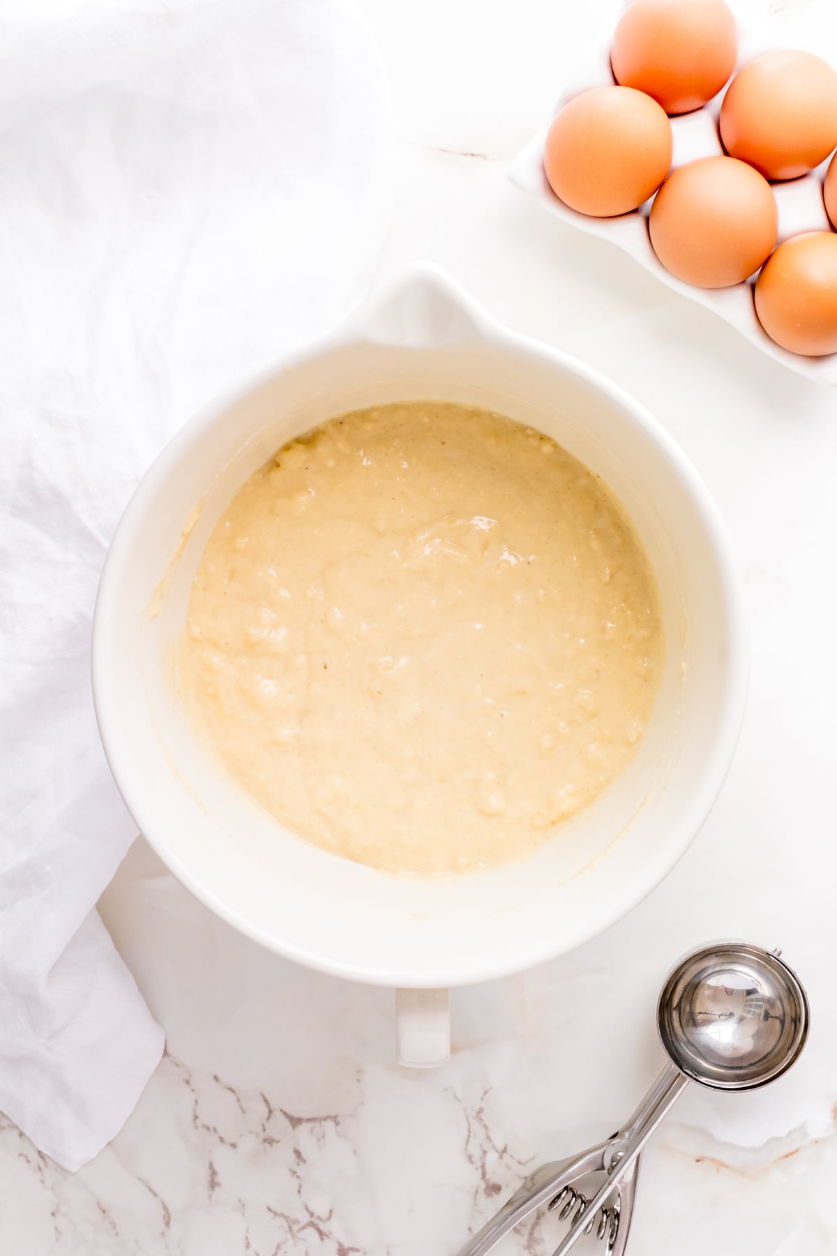 Wet ingredients added into a bowl of dry ingredients to make buttermilk waffle batter.
