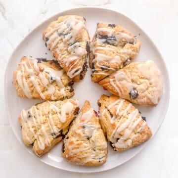 white round platter filled with blueberry scones on marble background.