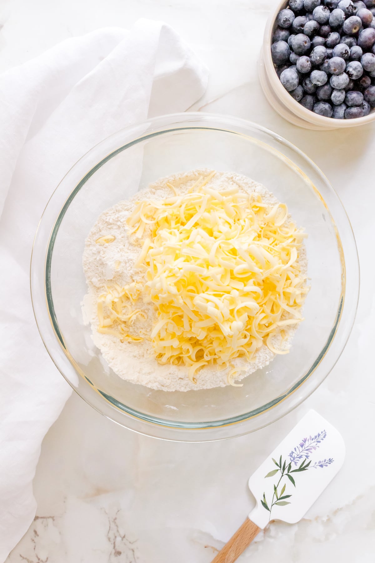 frozen butter grated into dry ingredients in glass mixing bowl.