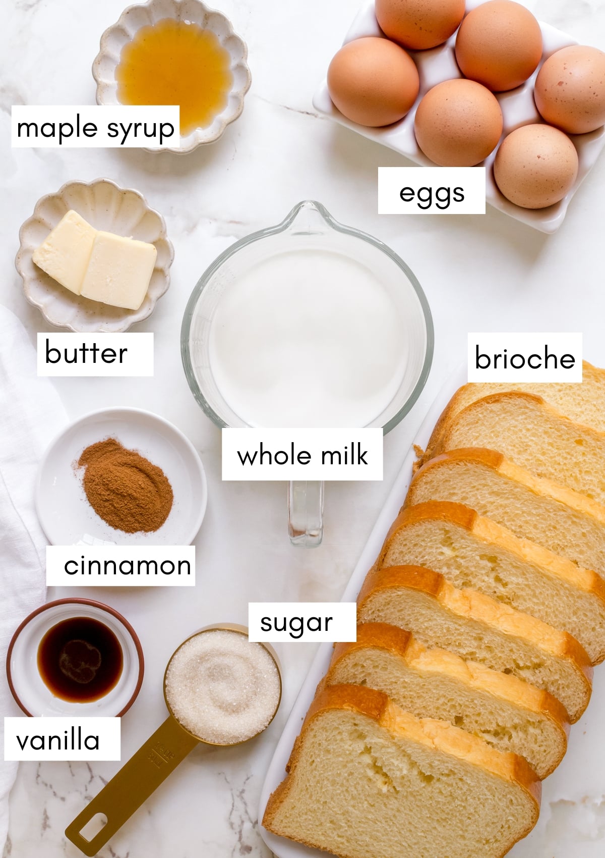 labeled ingredients for brioche French toast on marble background. 
