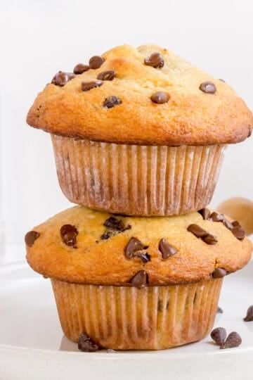 stack of chocolate chip banana muffins on white plate with mini chocolate chips.