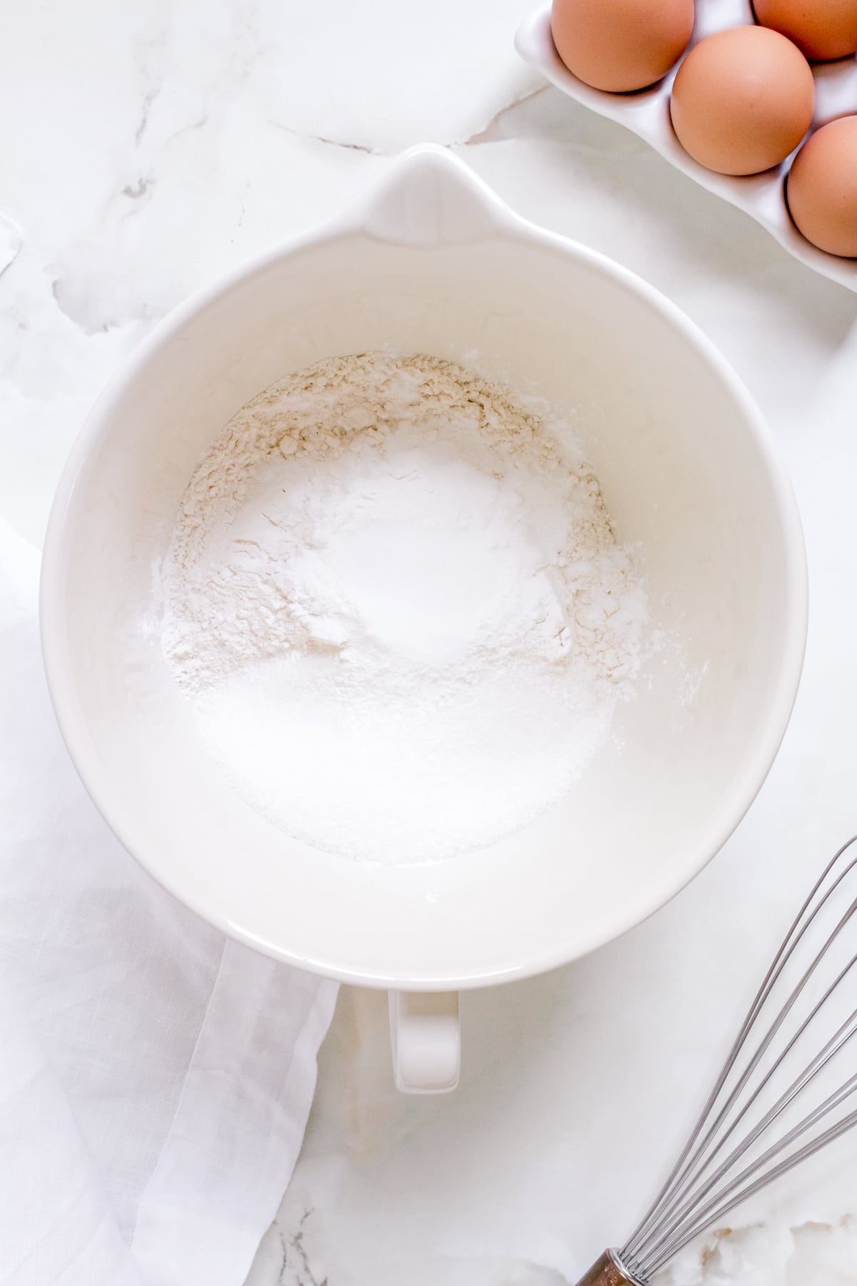 dry ingredients for discard pancakes in white porcelain mixing bowl.