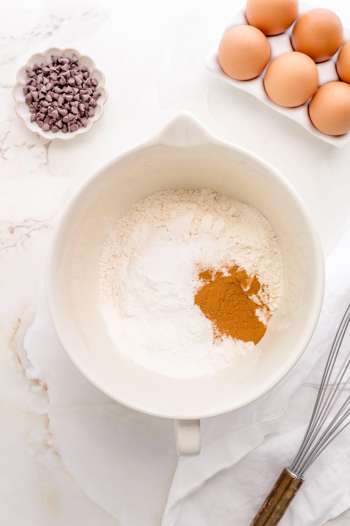 dry ingredients for chocolate chip pancakes in white mixing bowl.