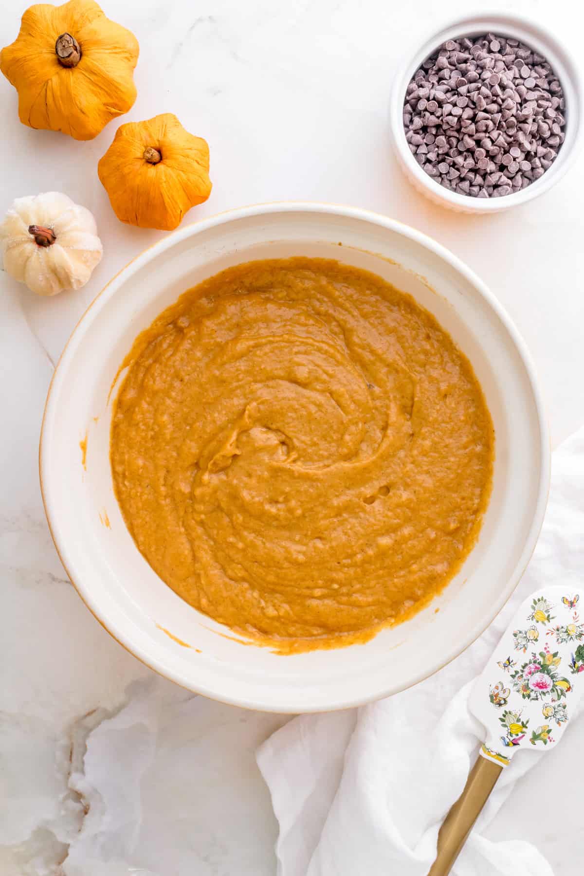 batter for pumpkin chocolate chip muffins in a white mixing bowl.