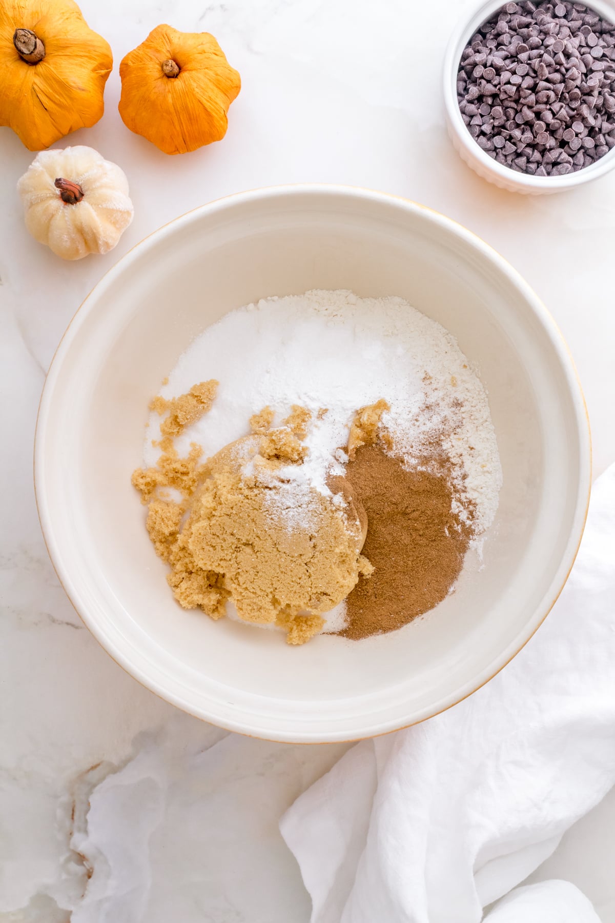 a large mixing bowl filled with dry ingredients for pumpkin chocolate chip muffins.